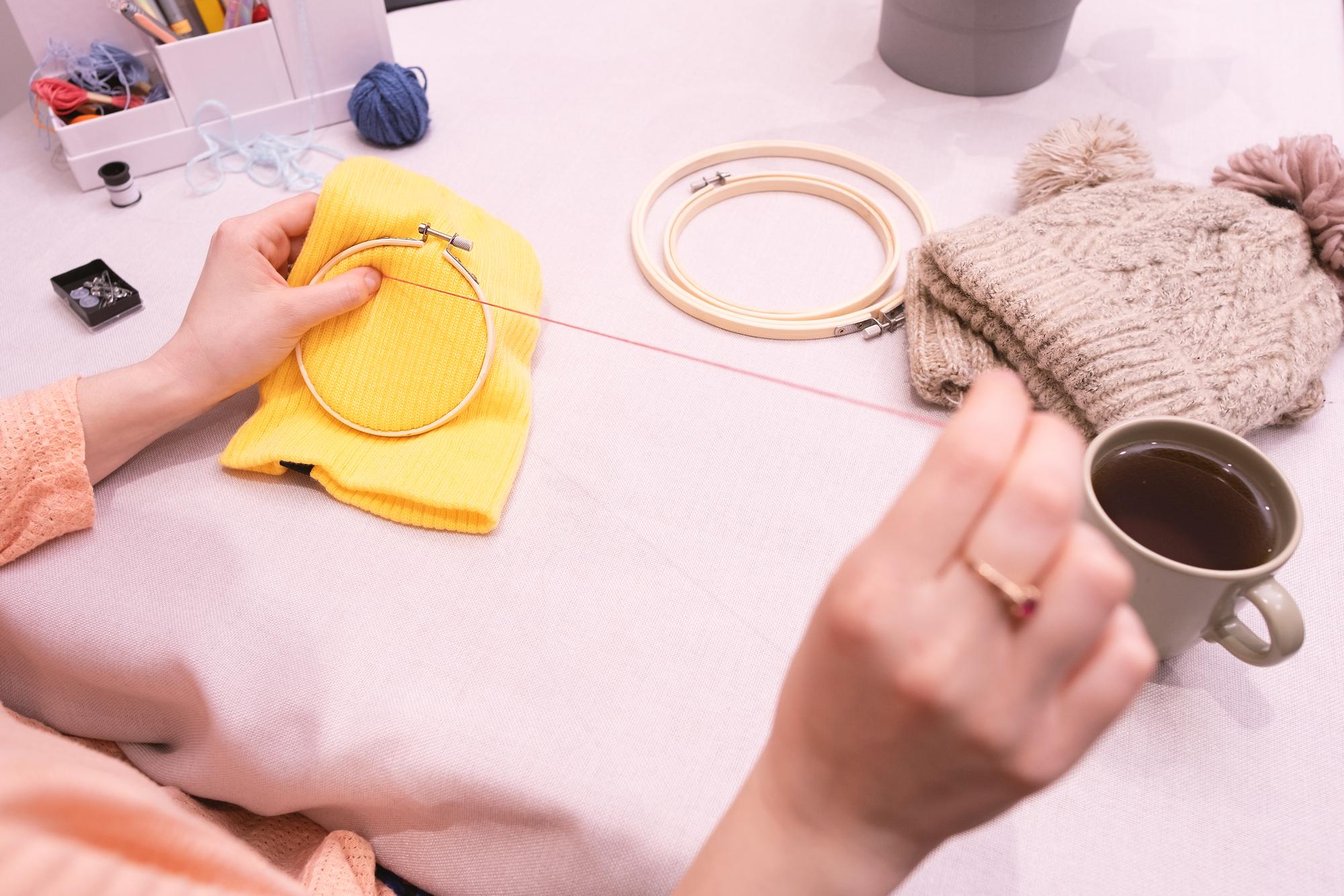 founder stitching at wooden table